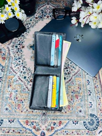 Interior view of an opened black leather bifold wallet showing multiple credit card slots and cash compartments