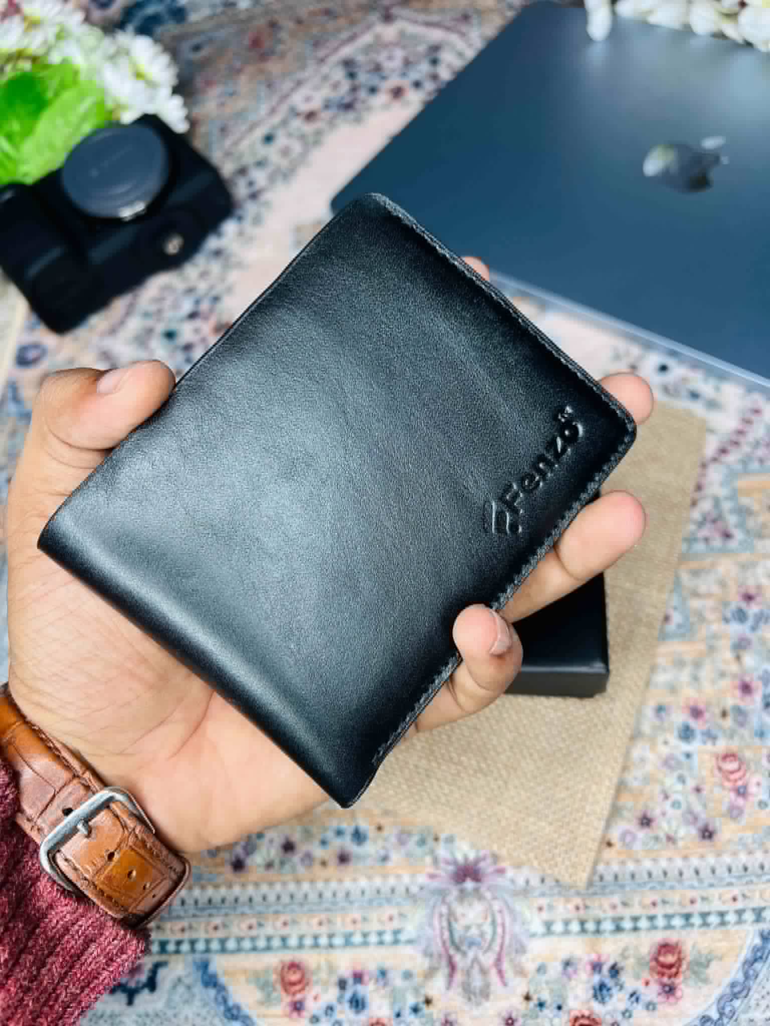 Premium leather bifold wallet held open with cards and bank notes inside